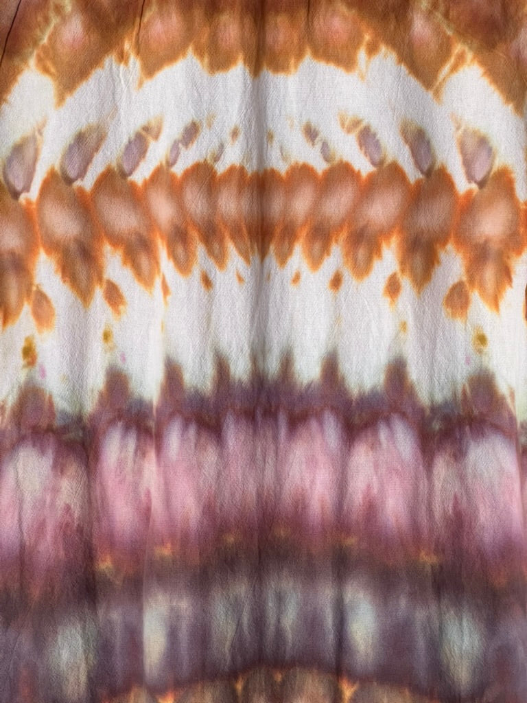 Close-up of tie-dye fabric with brown, white, and purple patterns