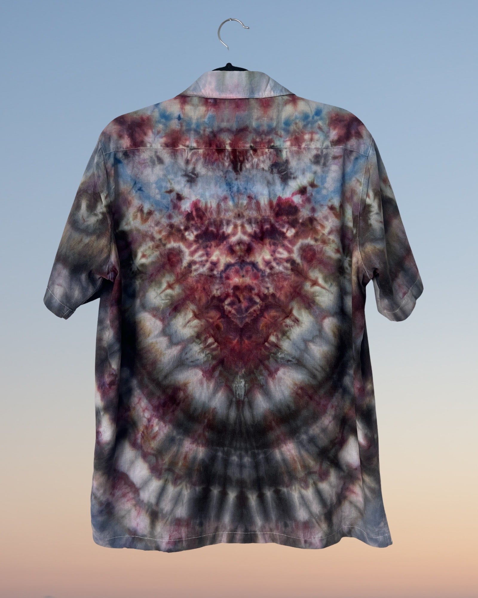 Tie-dye shirt on a hanger with a gradient background