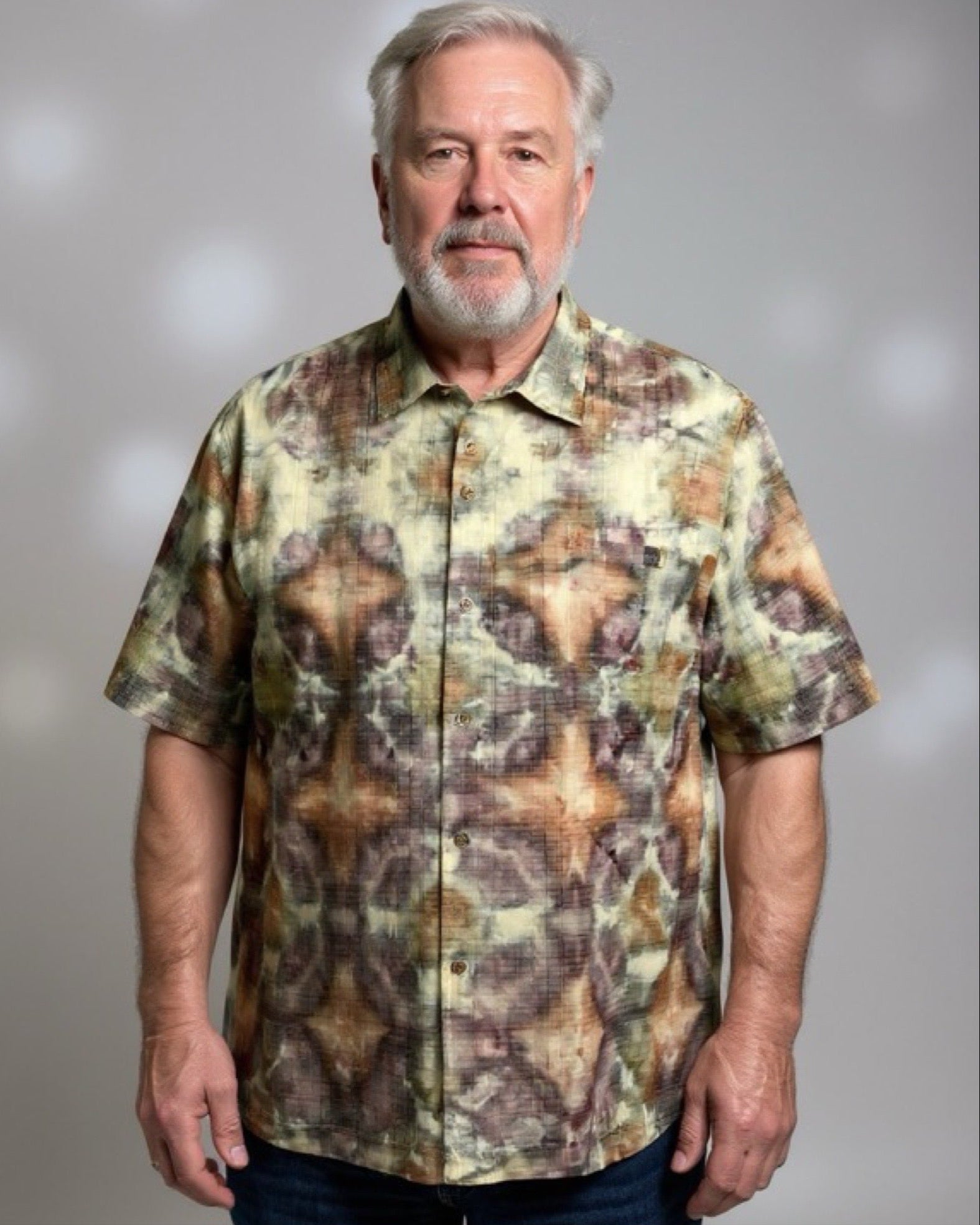 Man wearing a ice dyed shirt against a gray background