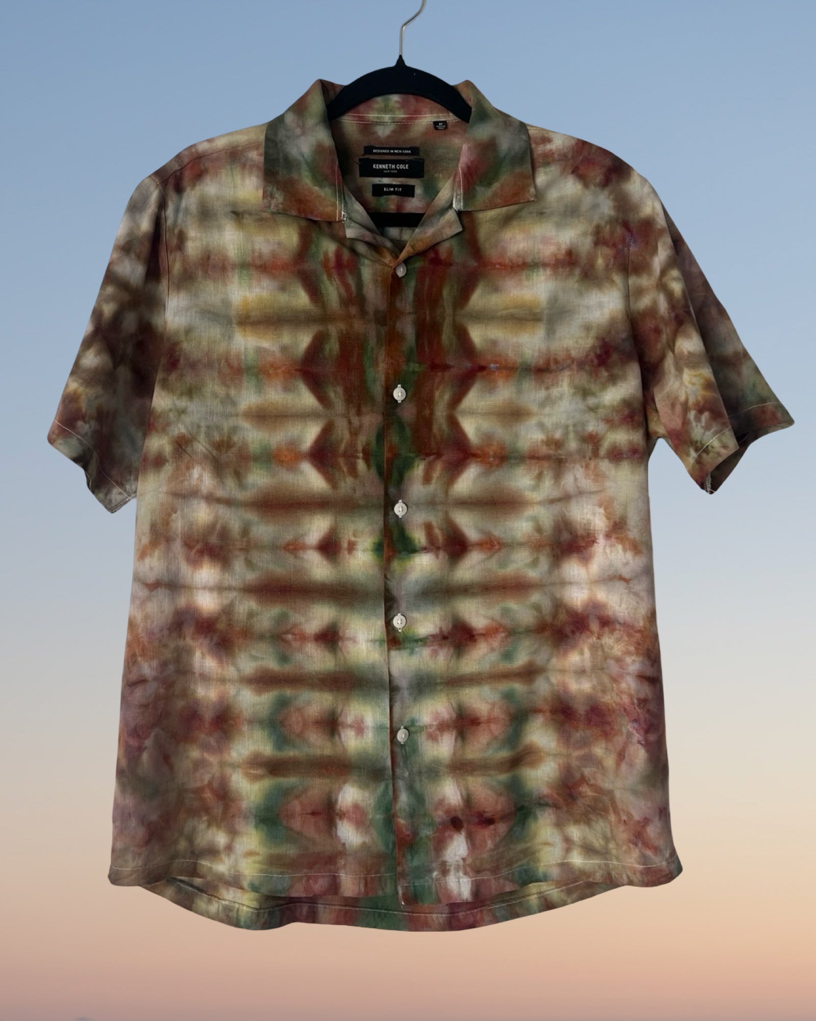 Tie-dye patterned shirt on a hanger with a gradient background