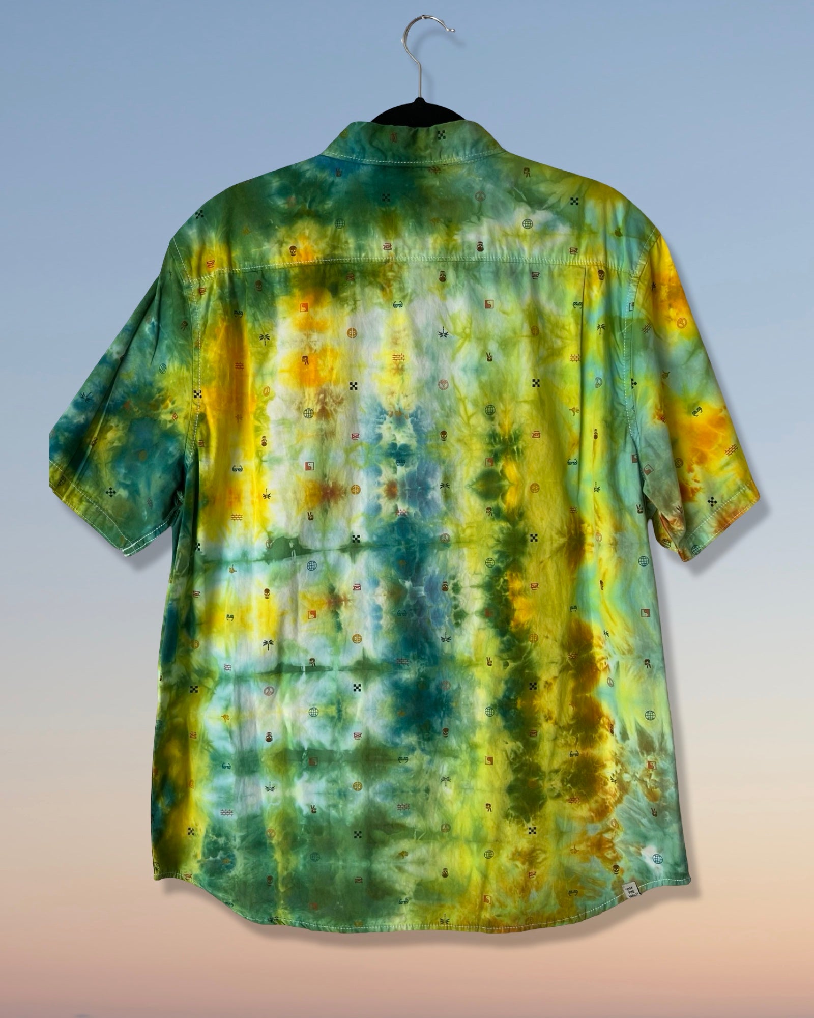 Tie-dye shirt with green, yellow, and blue pattern on a plain background