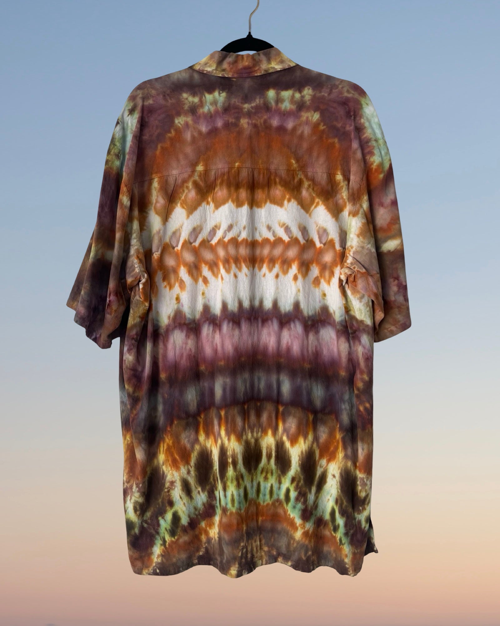 Tie-dye shirt on a hanger with a gradient background