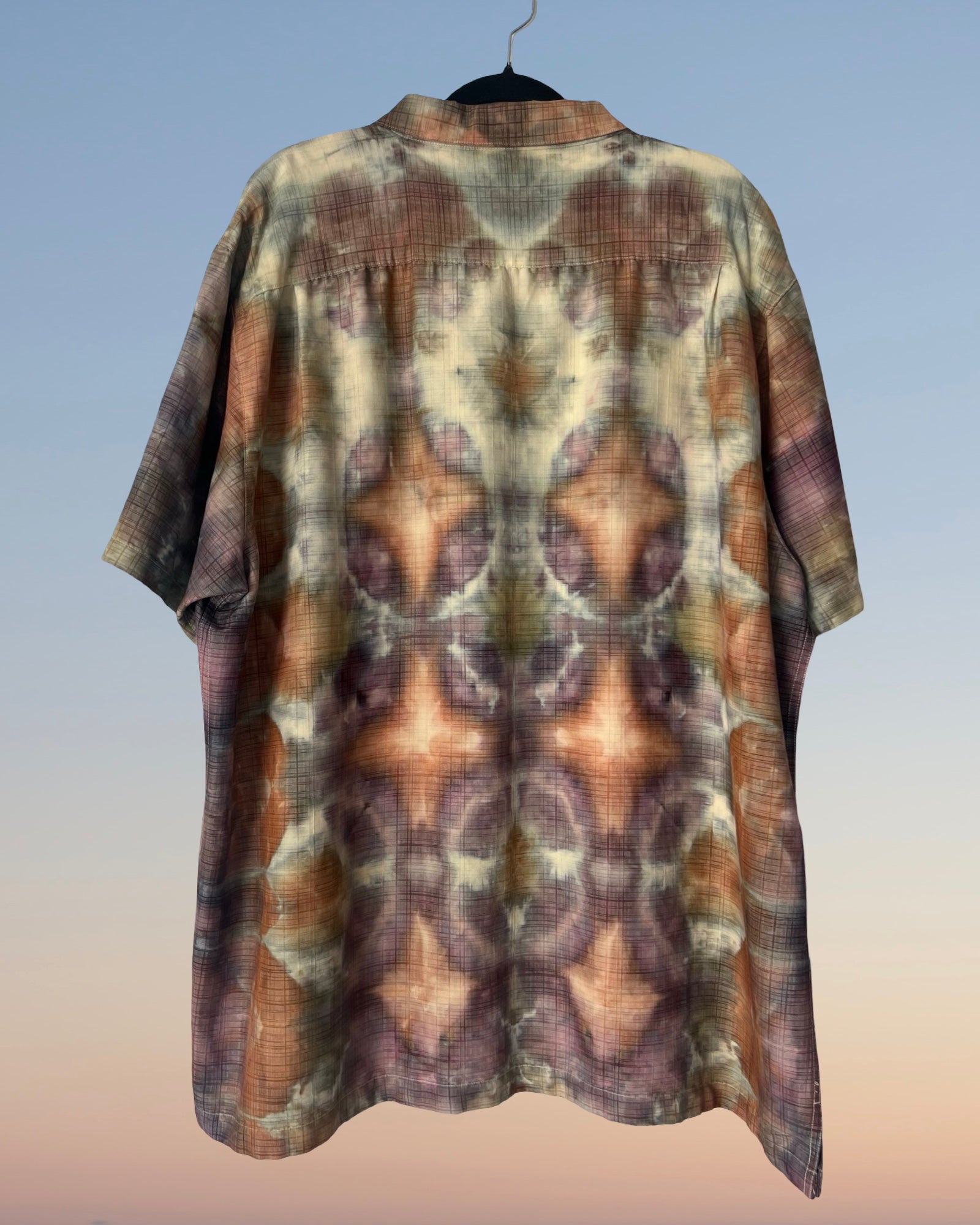 Short-sleeve shirt with a tie-dye pattern on a plain background