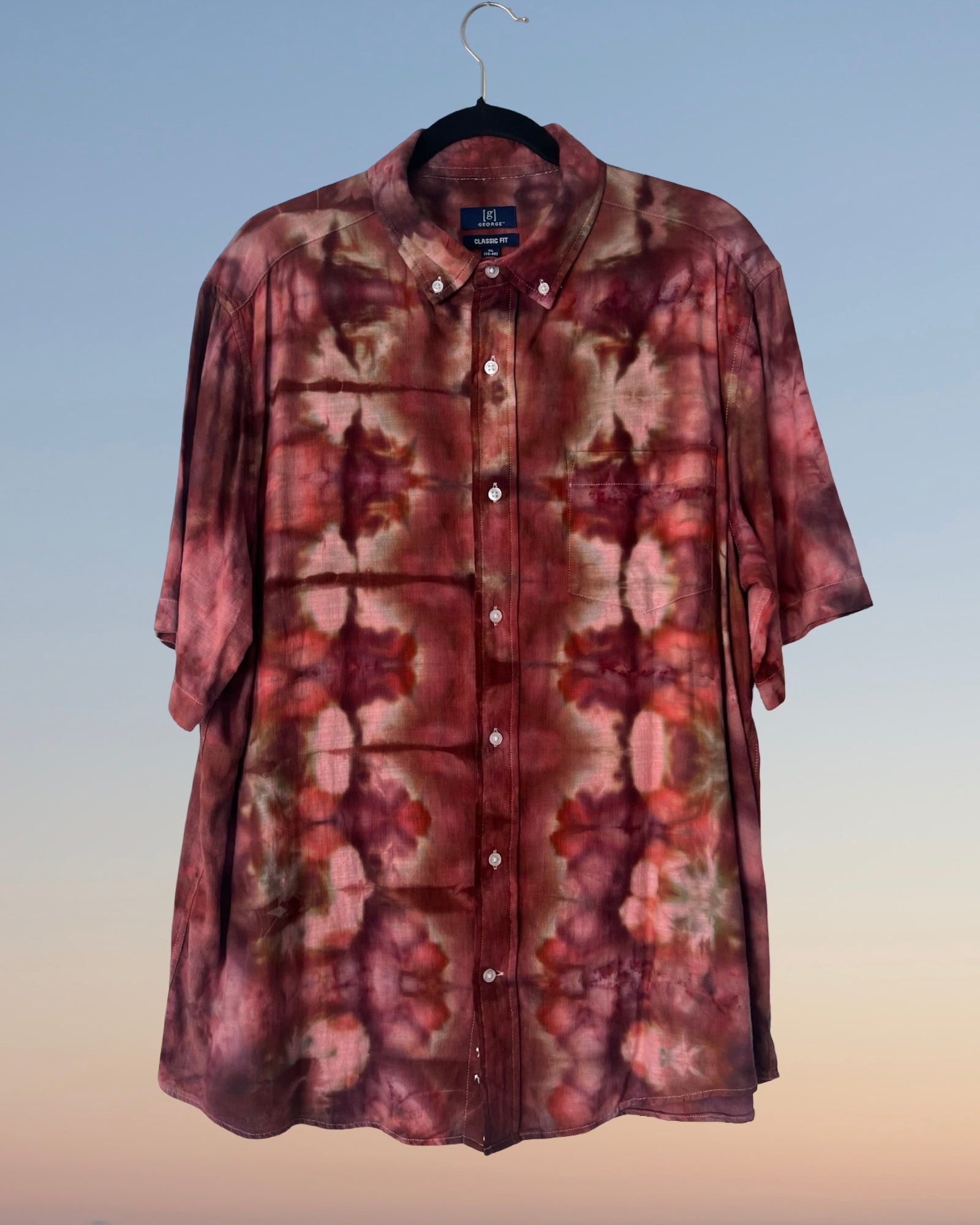 Ice dyed shirt on a hanger against a gradient background