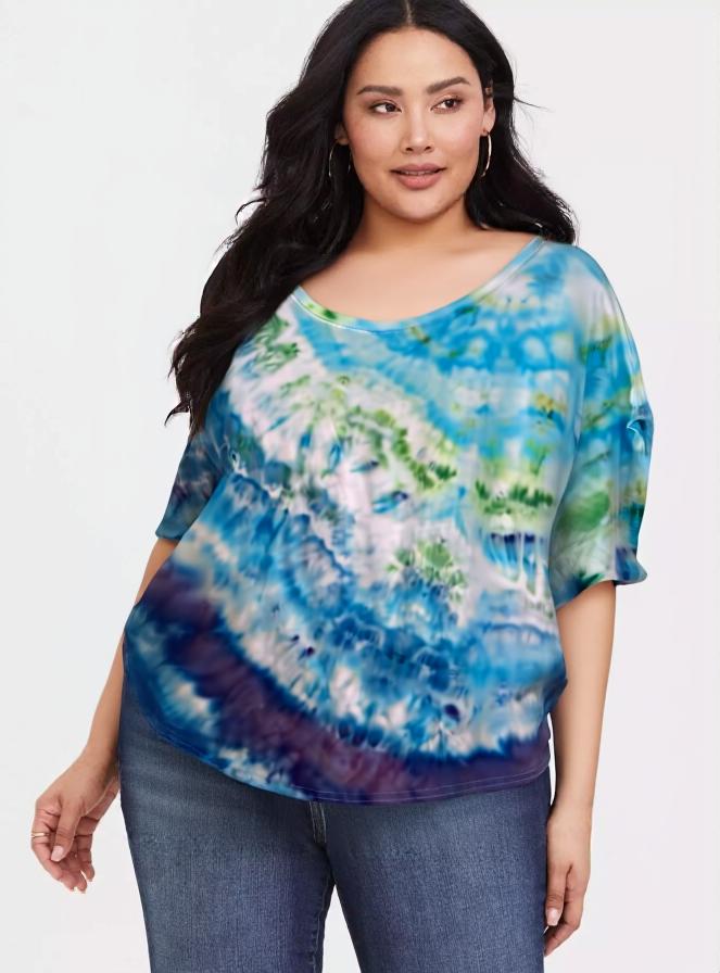 Woman wearing a tie-dye shirt with blue, green, and purple patterns on a white background