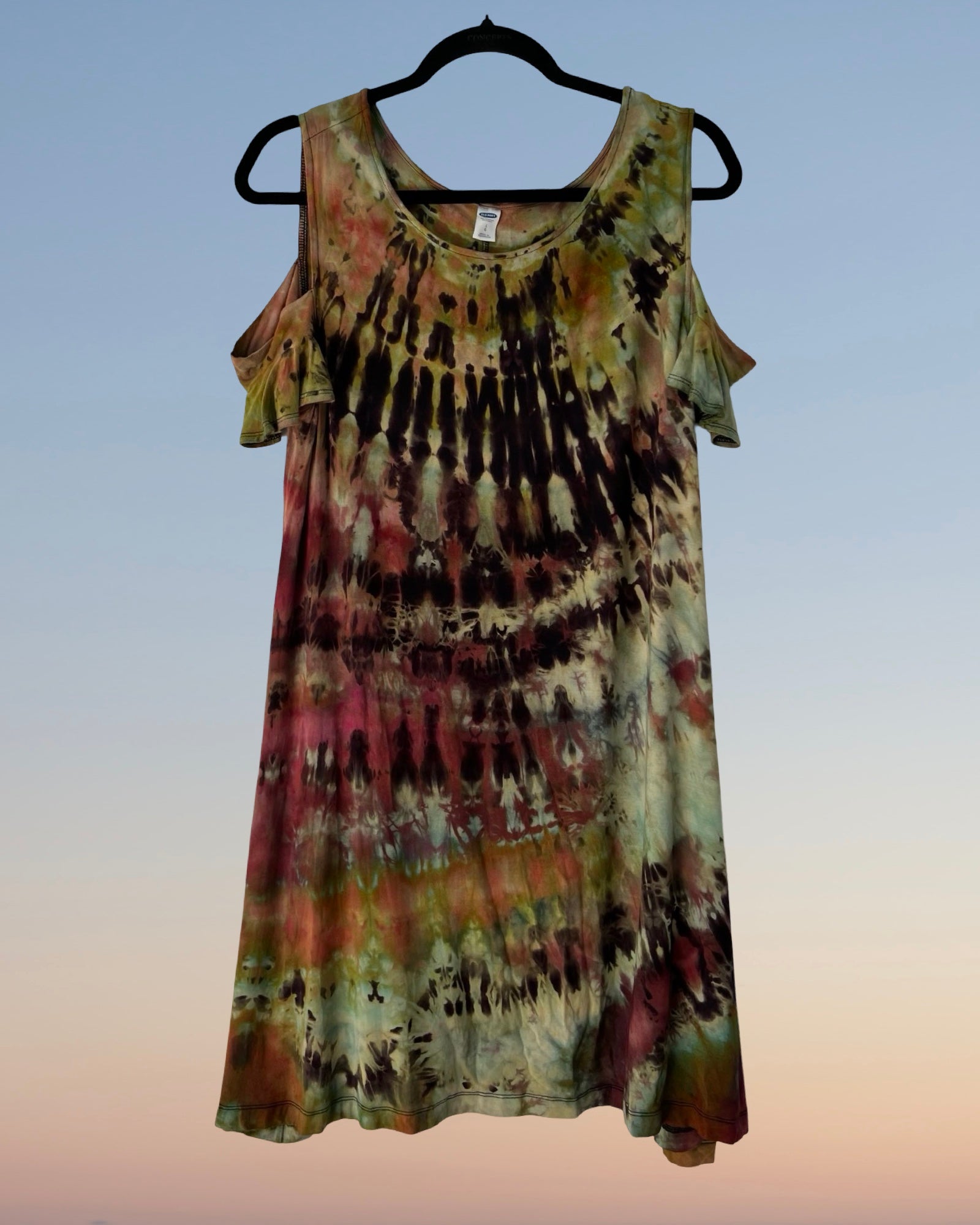 Tie-dye dress on a hanger against a gradient background