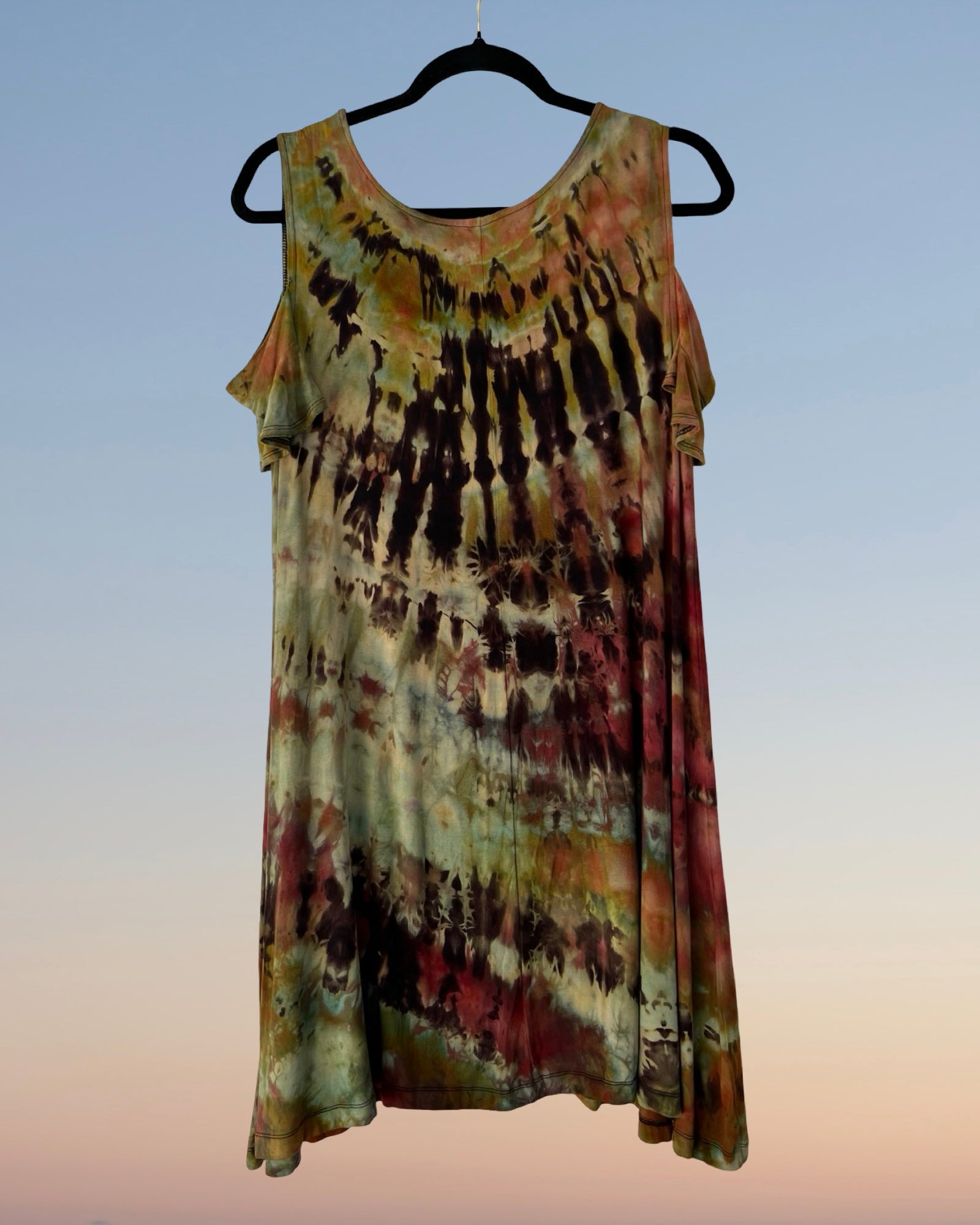 Tie-dye dress on a hanger against a gradient background