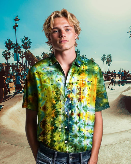 Person wearing a colorful tie-dye shirt at a skate park with palm trees in the background