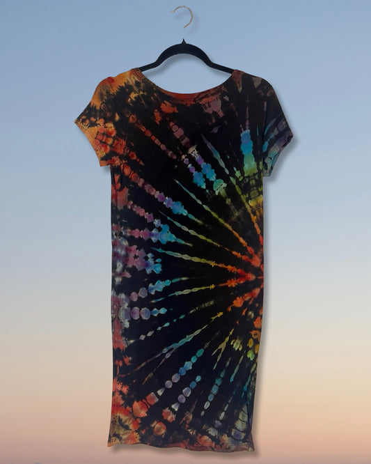 Tie-dye dress on a hanger against a light blue wall