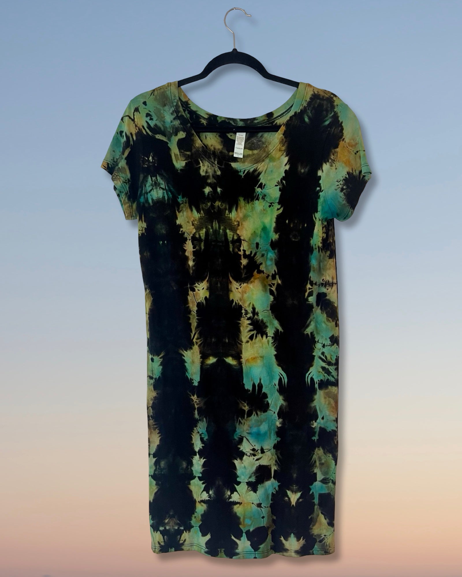 Tie-dye dress on a hanger against a gradient background