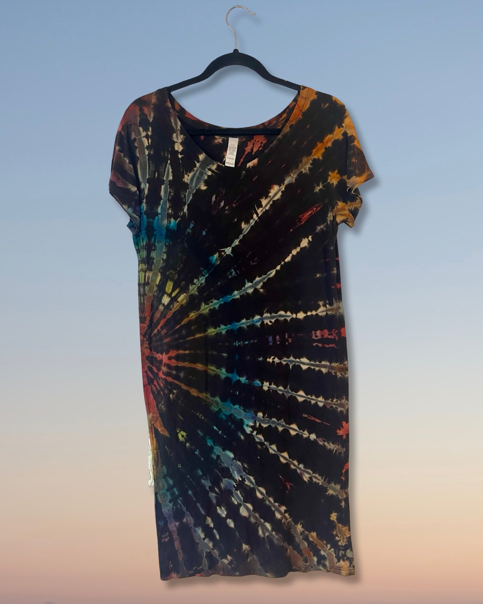 Tie-dye dress on a hanger against a gradient background
