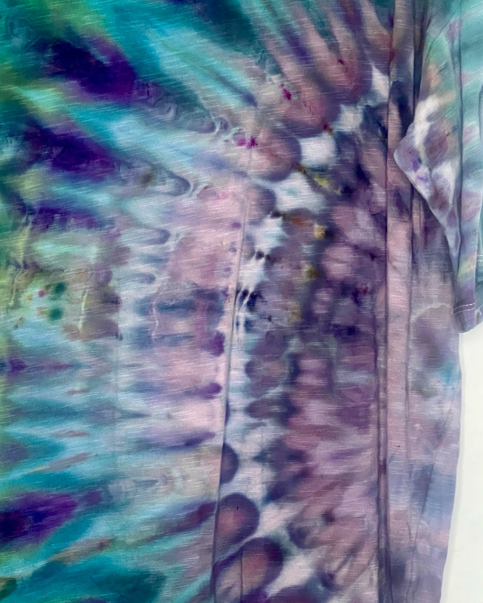Close-up of a tie-dye pattern with purple, blue, and green colors.