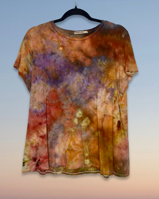 Multicolored tie-dye shirt on a hanger against a gradient background