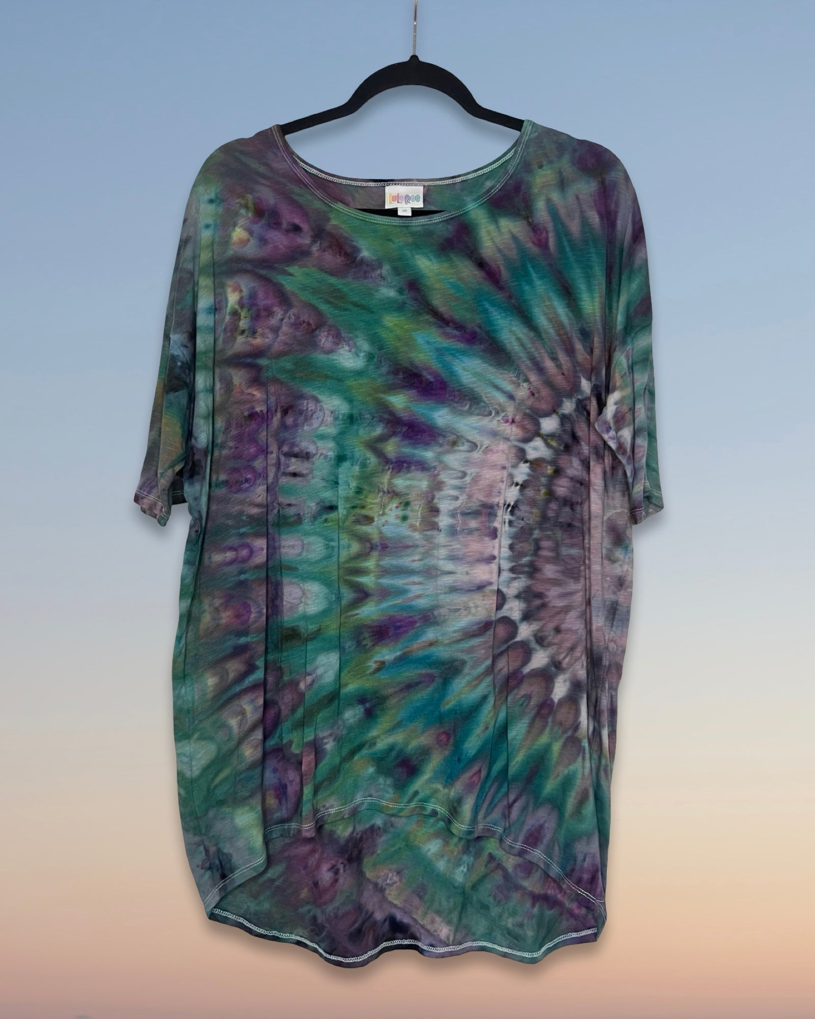 Tie-dye shirt on a hanger with a gradient background