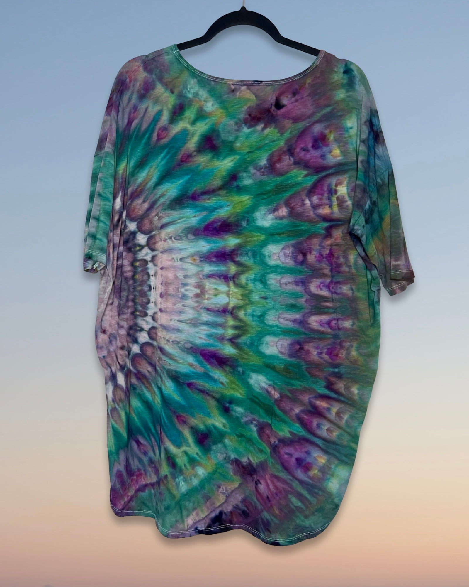 Tie-dye shirt on a hanger with a gradient background