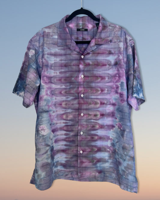 Short-sleeve shirt with a tie-dye pattern on a hanger against a gradient background