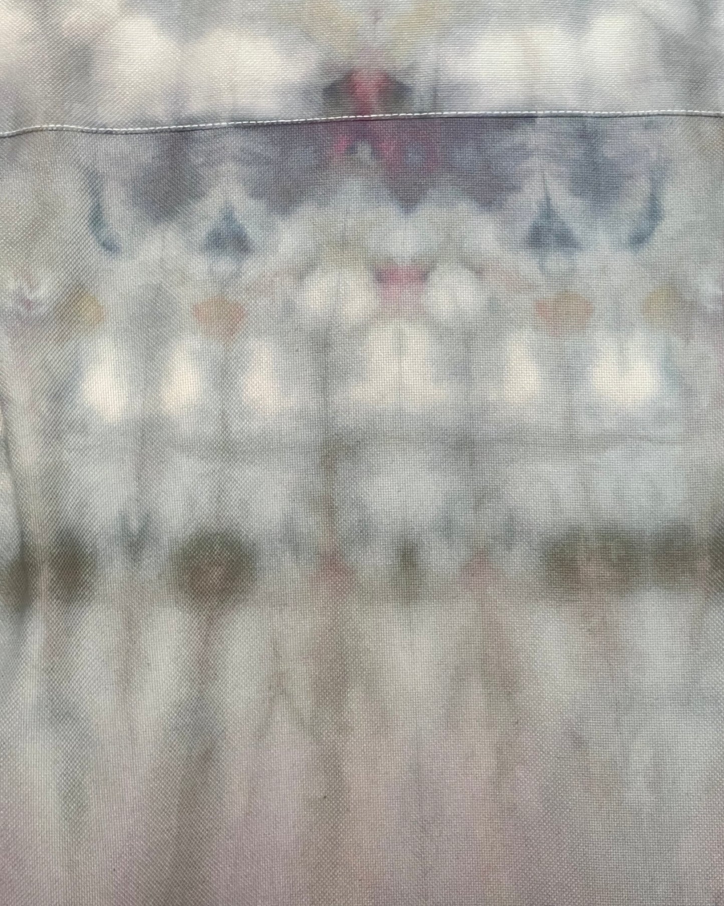 Tie-dye shirt with blue and green patterns on a plain background