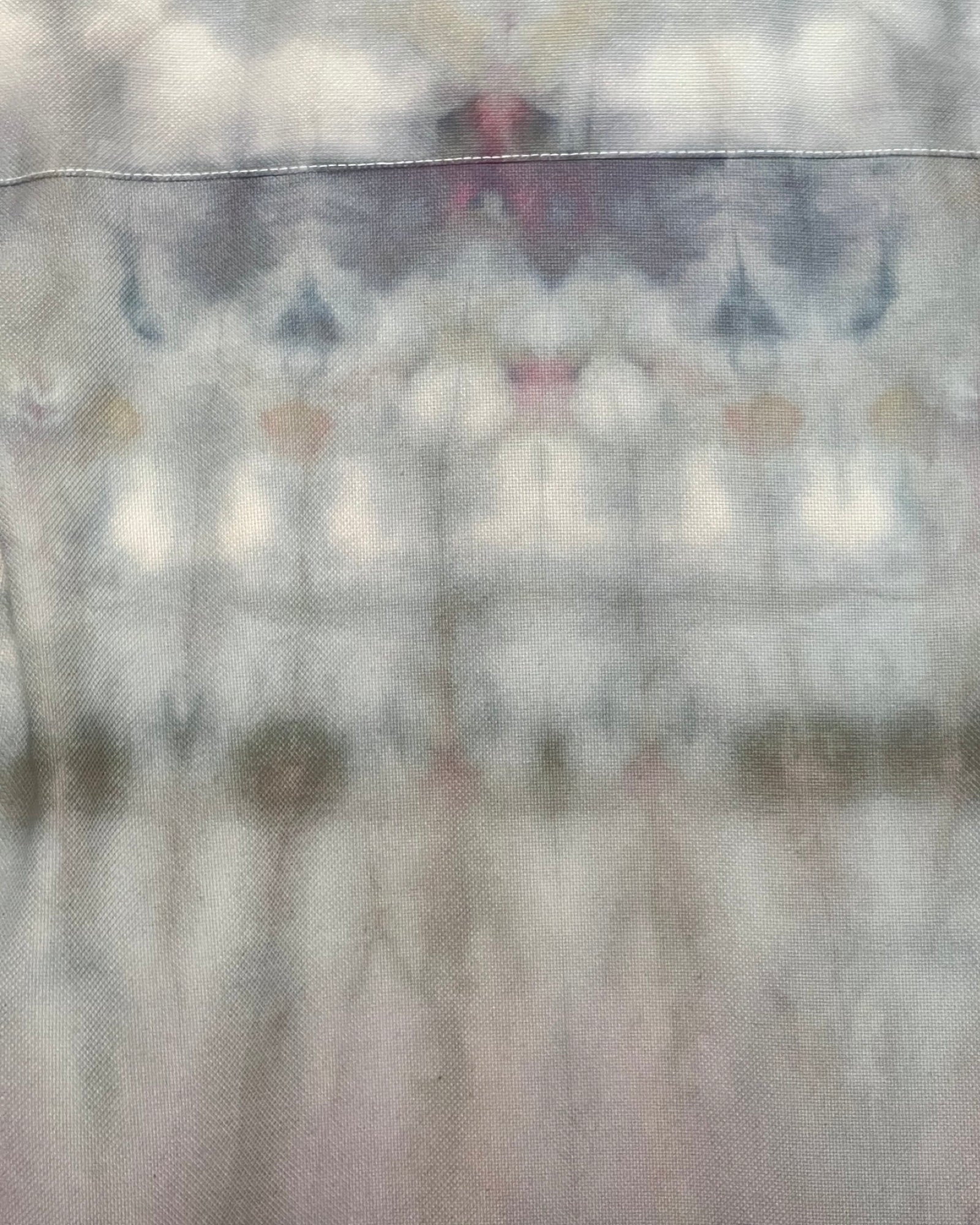 Tie-dye shirt with blue and green patterns on a plain background