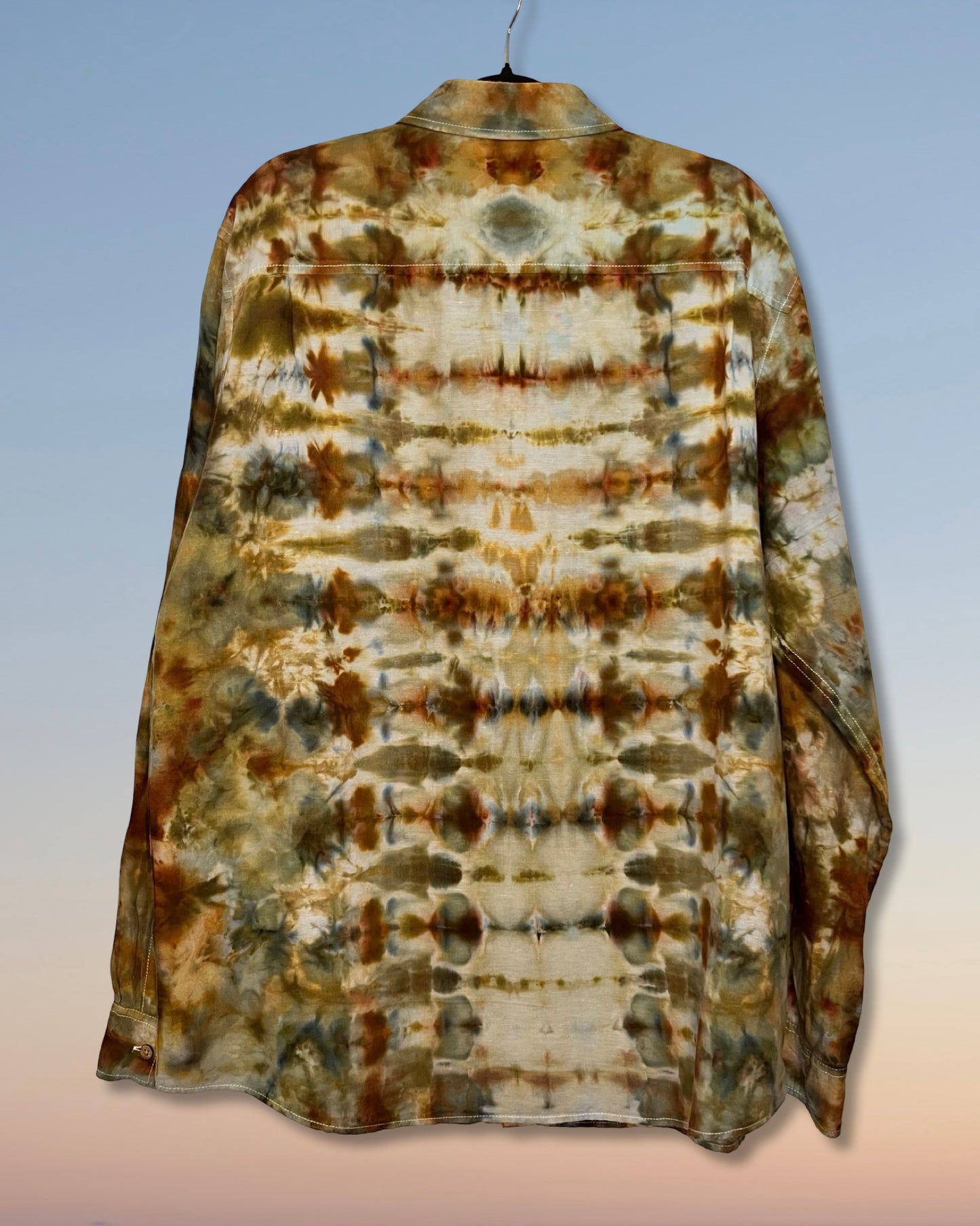 Tie-dye shirt with brown and beige patterns on a gradient background