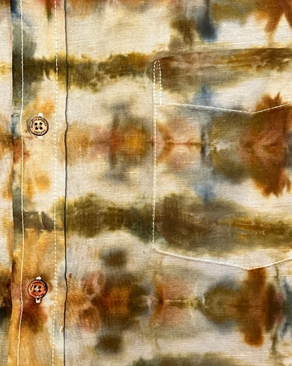 Close-up of a tie-dye shirt with brown, beige, and blue patterns.