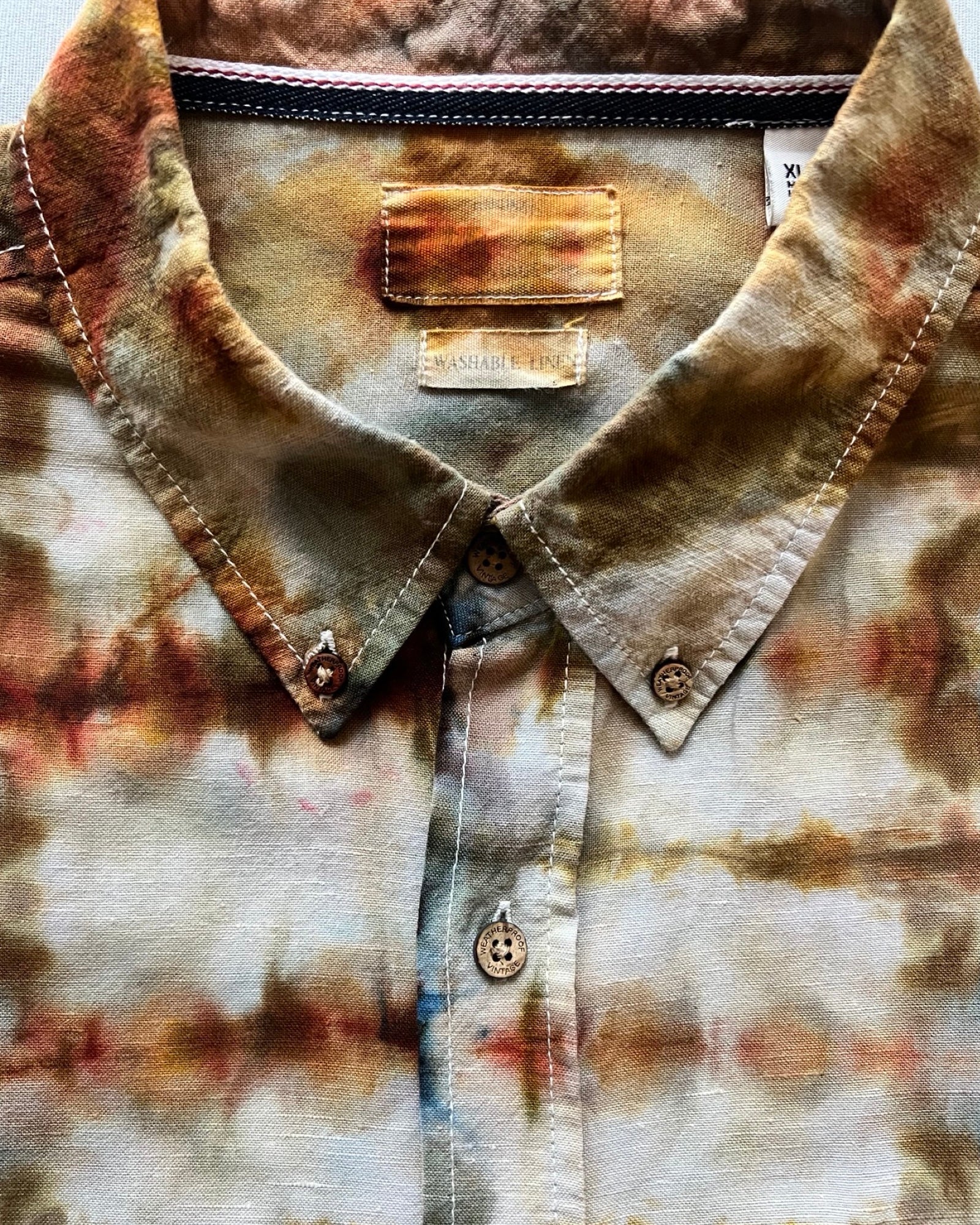 Close-up of a tie-dye shirt with multicolor patterns on a plain background