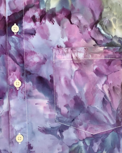 Close-up of a floral-patterned tie dye shirt with a pocket and buttons.