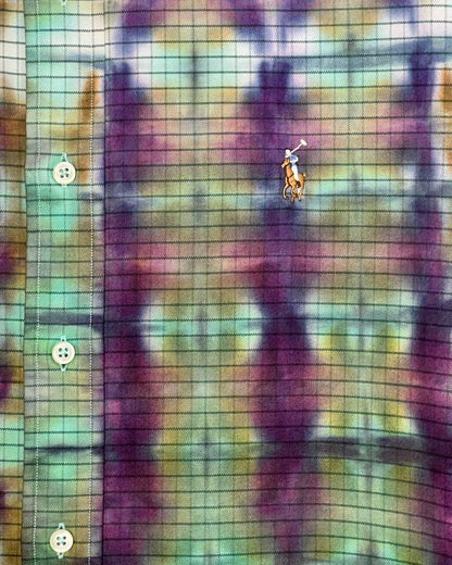 Abstract tie-dye pattern with purple, mint blue, and beige colors on a fabric background.