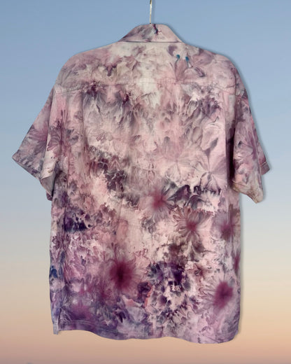 Floral patterned ice dyed shirt on a hanger against a gradient background