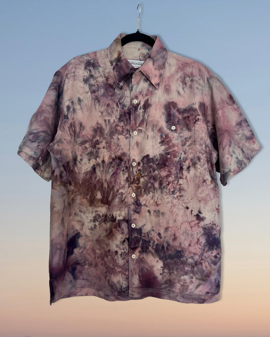 Floral patterned ice dyed shirt on a hanger against a gradient background