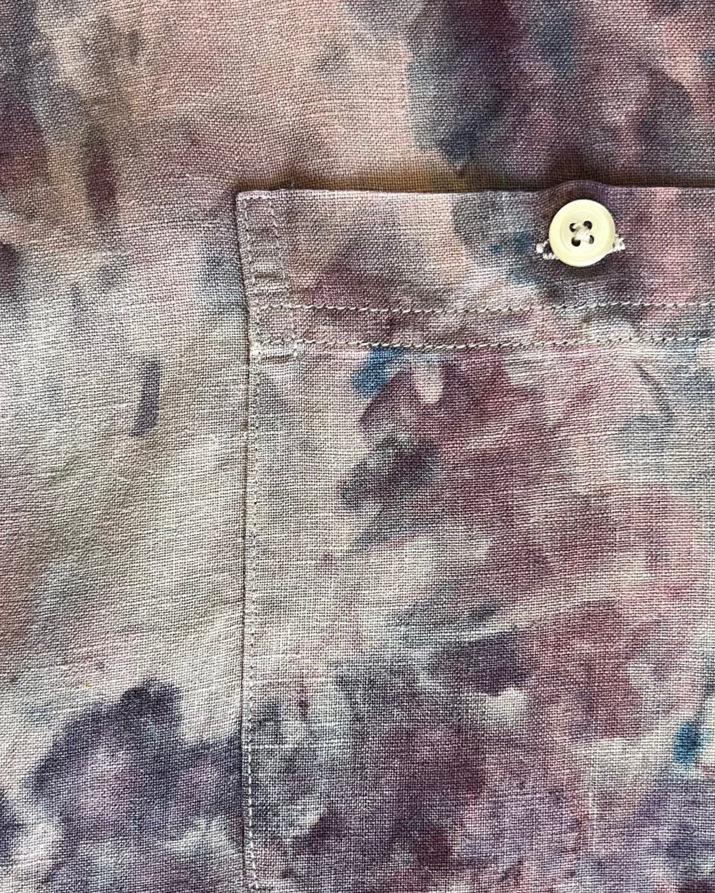 Close-up of a shirt with a button and watercolor pattern
