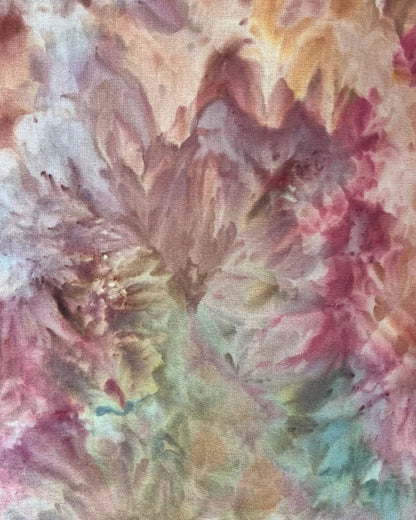 Close-up of a tie-dye fabric with pink, green, and brown colors.