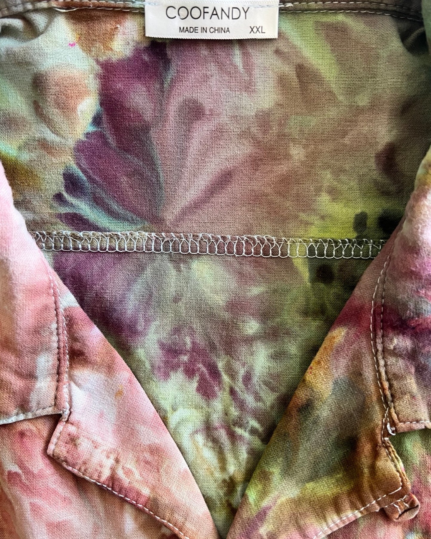 Close-up of a tie-dye shirt with a brand label on a multicolored background