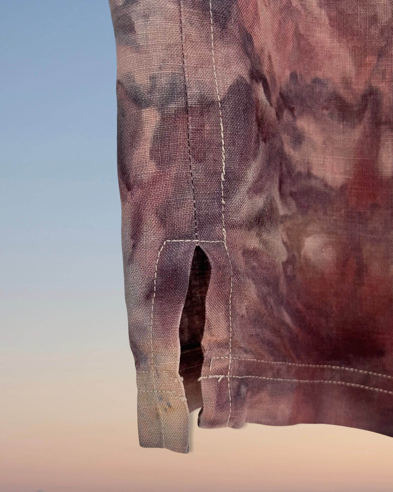 Close-up of a floral ice dyed camouflage-patterned fabric with a pocket detail on a gradient background