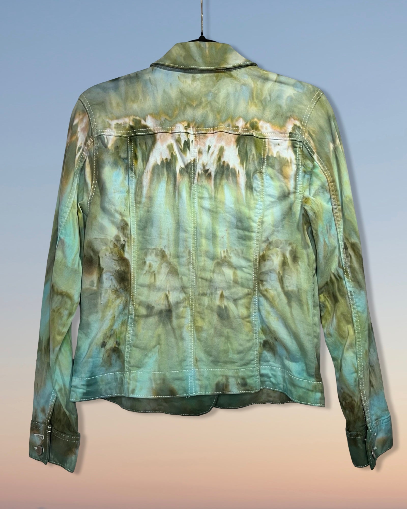 Tie-dye denim jacket on a hanger with a gradient background