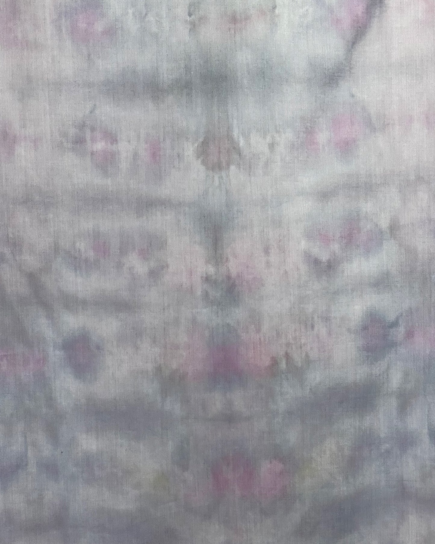 Textured fabric with a subtle tie dye pattern on a light gray background